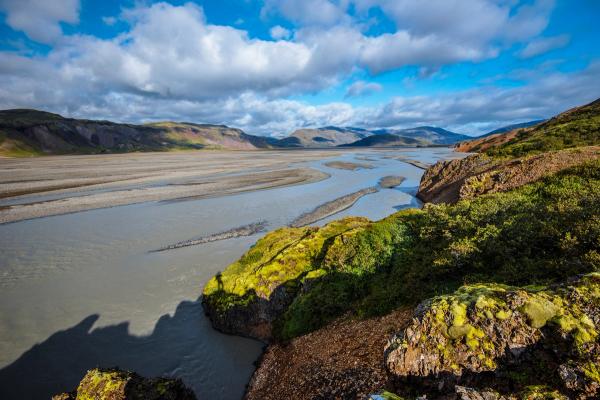 a river flowing through a valley surrounded by mountains on a sunny day, Lónsöræfi