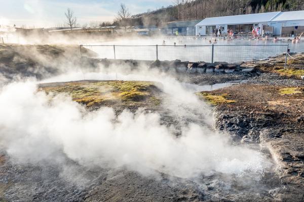 a group of people are swimming in a hot spring .
