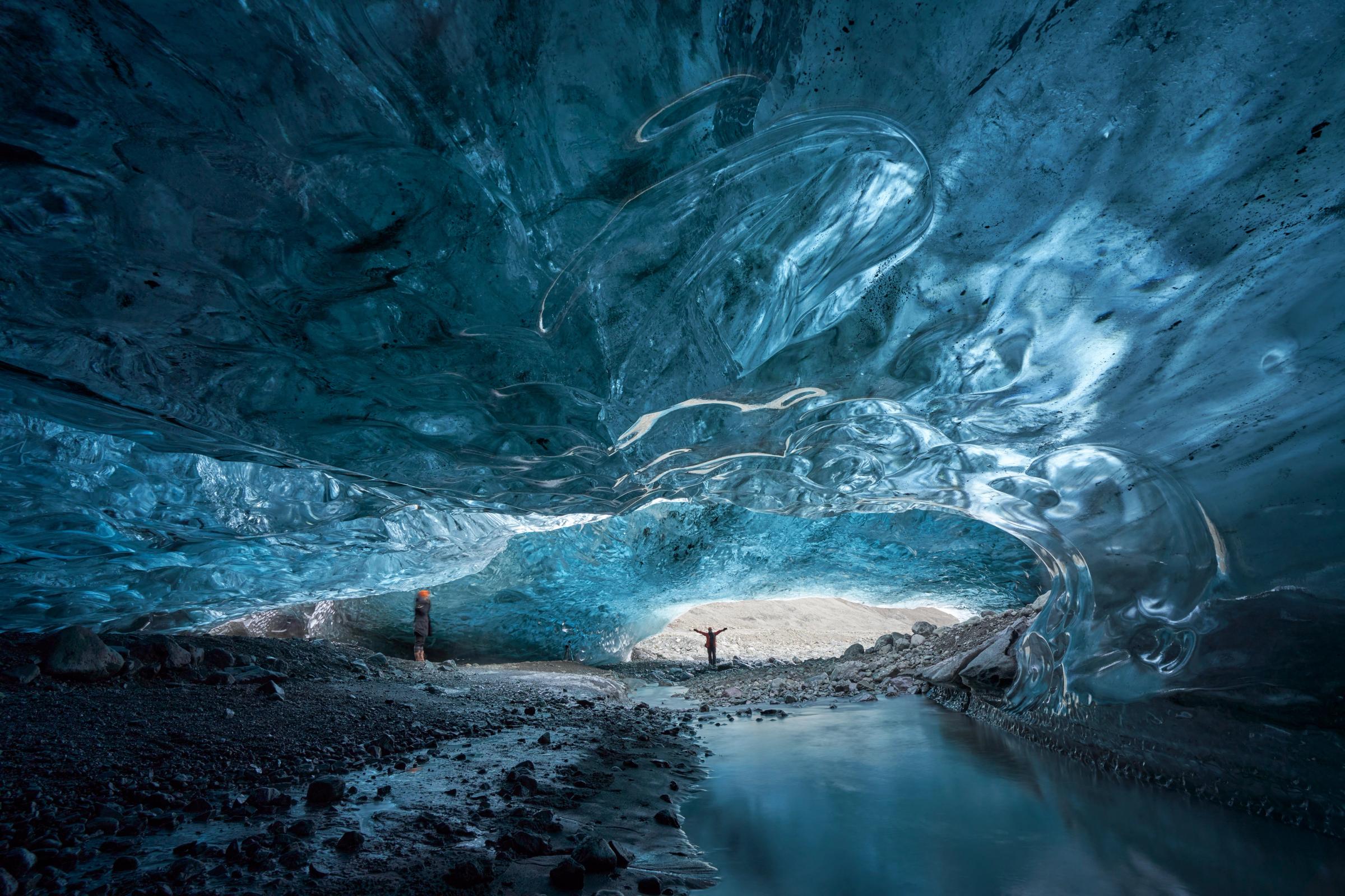 a man is standing in the middle of an ice cave .