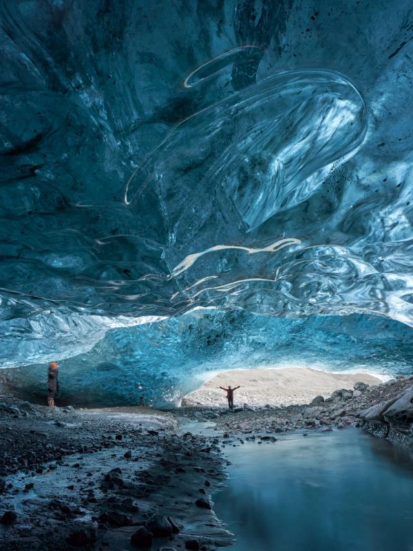 a man is standing in the middle of an ice cave .