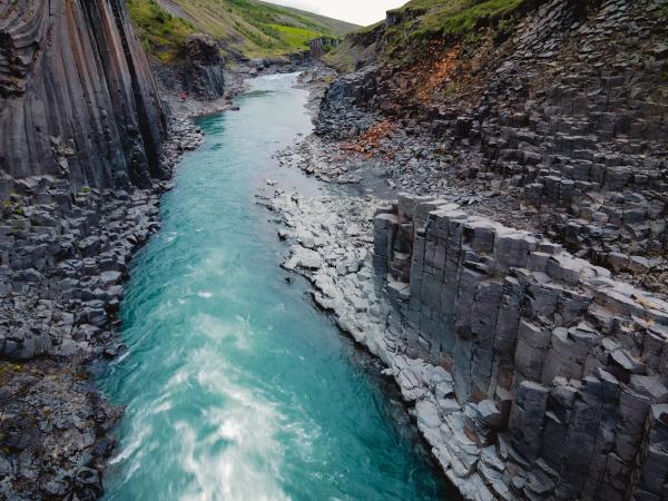 an aerial view of a river flowing through a canyon surrounded by rocks .