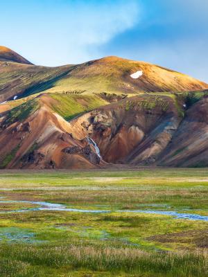 a river running through a grassy field with mountains in the background, Landmannalaugar