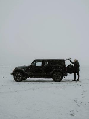 Iceland rental car view on a black Iceland jeep rental parked in the snow in Iceland.