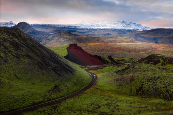 a car is driving down a road in the mountains .