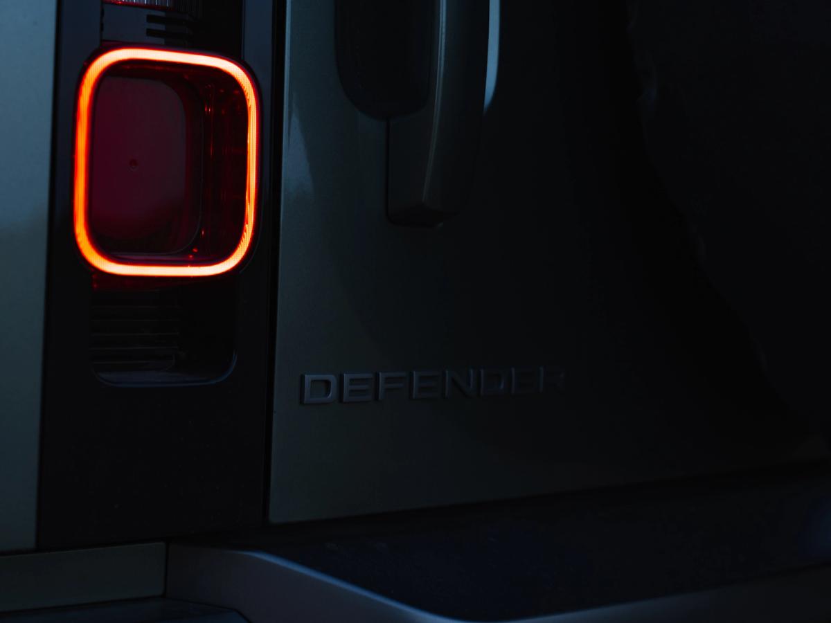 Piloto trasero e insignia del Defender de noche Primer plano de la luz trasera y el emblema iluminados de un Land Rover Defender por la noche, un coche de alquiler de Go Car Rental Iceland