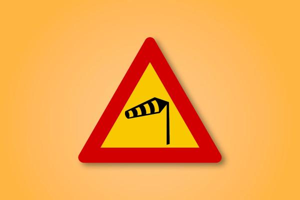 a yellow and red triangle sign with a windmill on it .