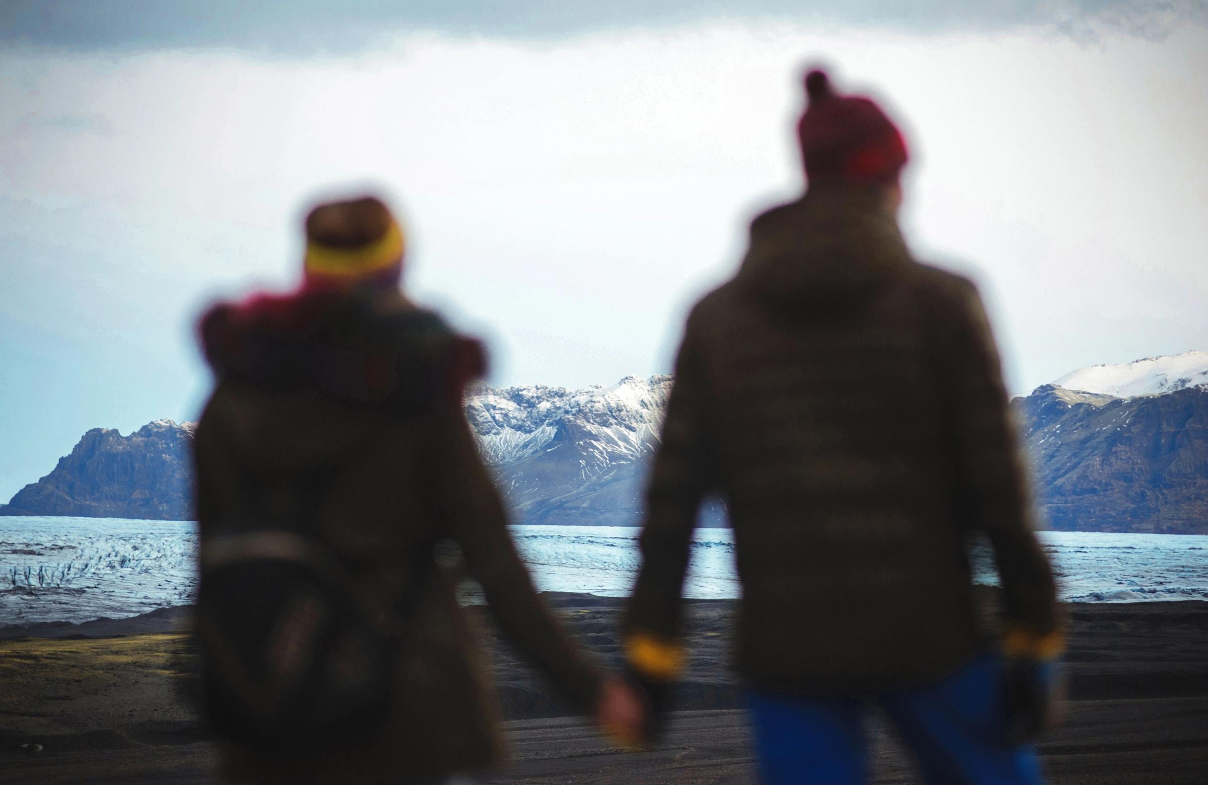 Pareja vestida con gorro y capas en Islandia