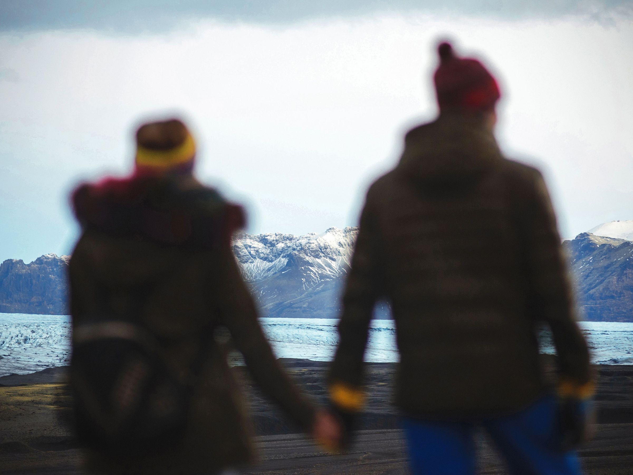 Pareja vestida con gorro y capas en Islandia