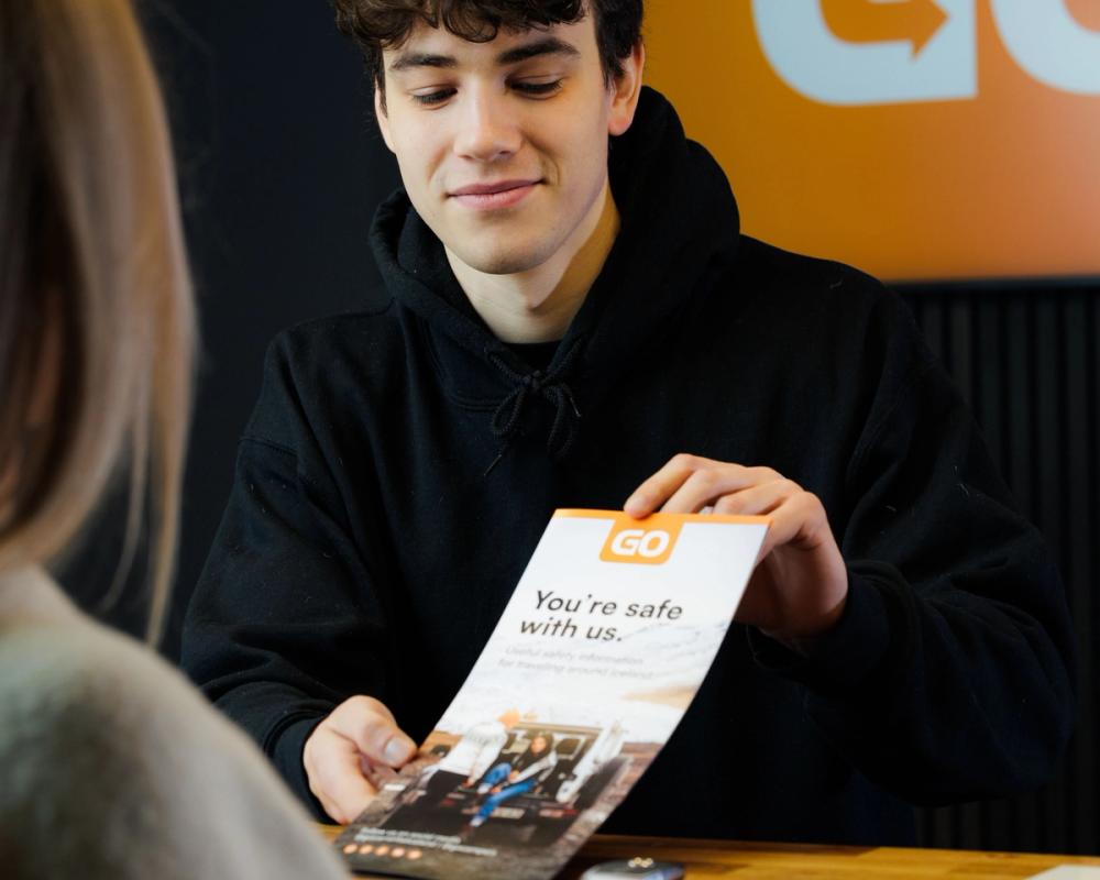 a man is holding a pamphlet that says " you 're safe with us "