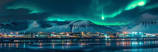 Aeropuerto con montañas nevadas detrás y la aurora boreal en el cielo
