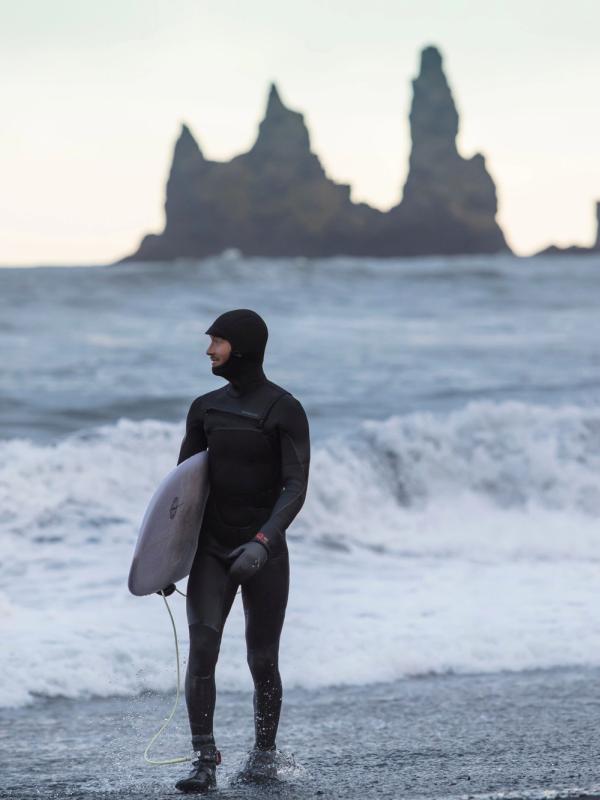 Man who surfs in a cold weather in Iceland