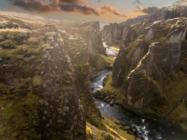 an aerial view of a river flowing through a canyon surrounded by mountains .