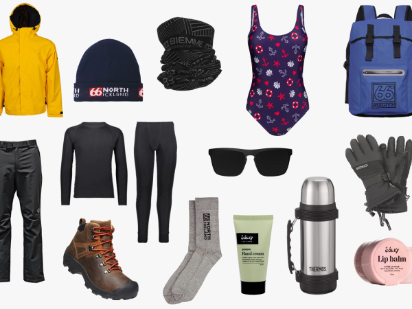 A flat lay of travel essentials including a yellow jacket, blue beanie, swimsuit, blue backpack, thermal clothing, hiking boots, gloves, sunglasses, a thermos, and skincare.