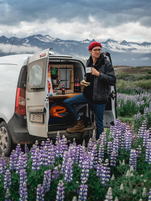 a man standing next to a white campervan