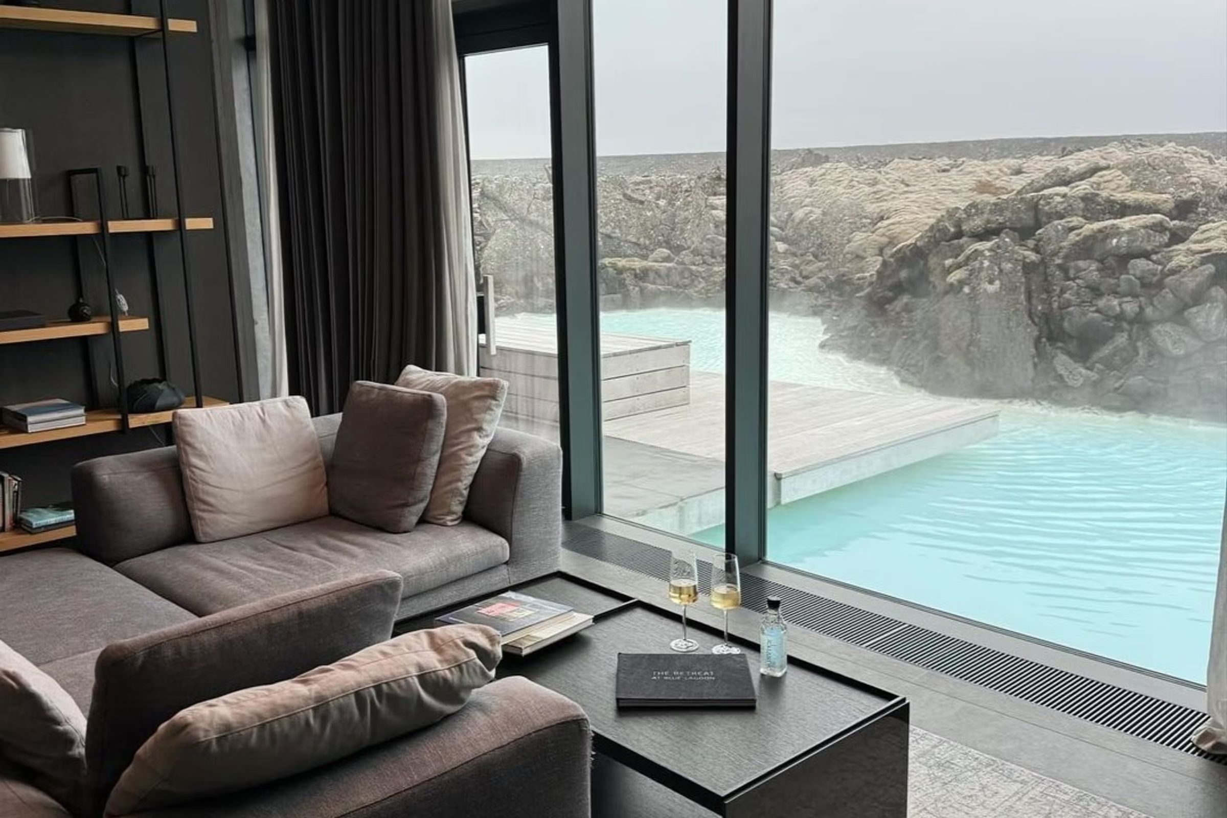 una sala de estar con un sofá y una mesa con vista a una piscina .