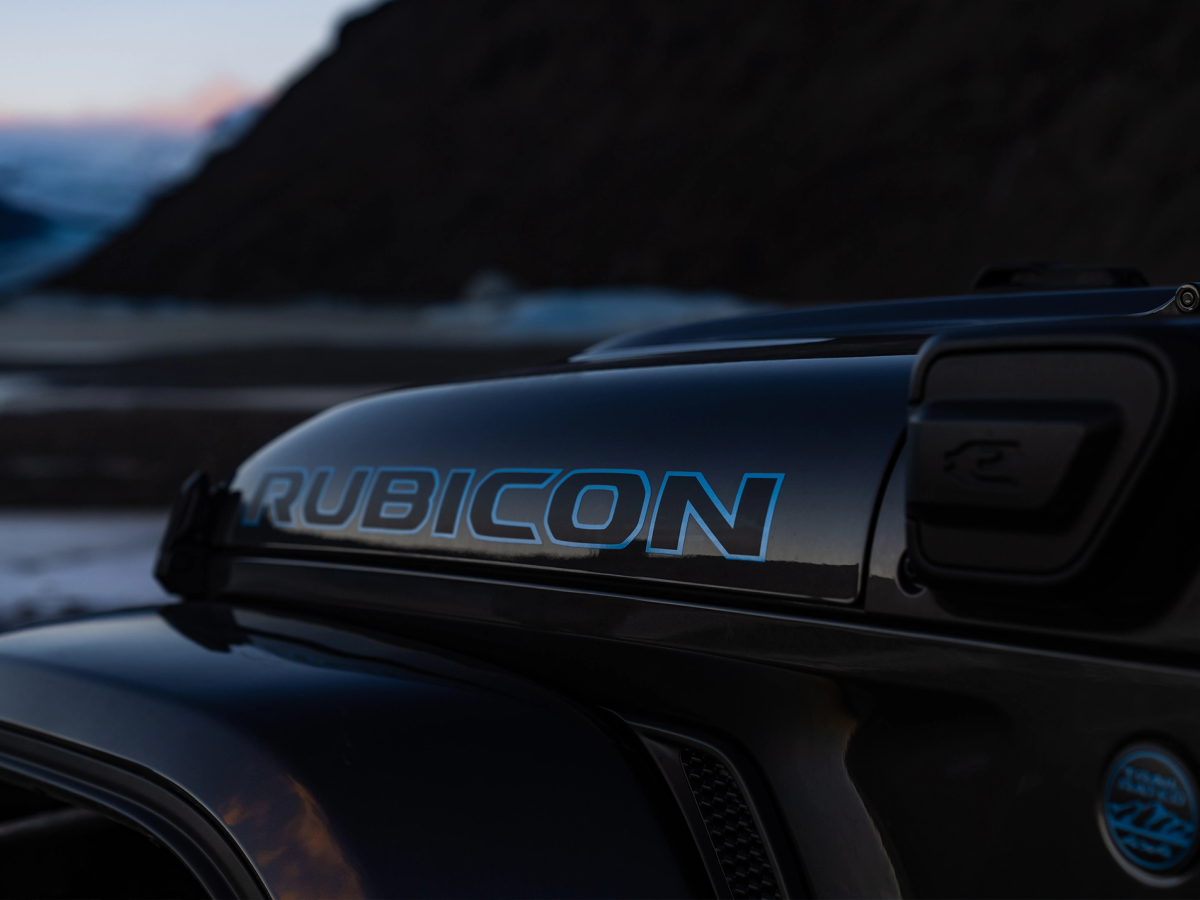 牧马人 Rubicon 引擎盖徽标 Jeep牧马人Rubicon引擎盖徽标特写,背景为海岸风光