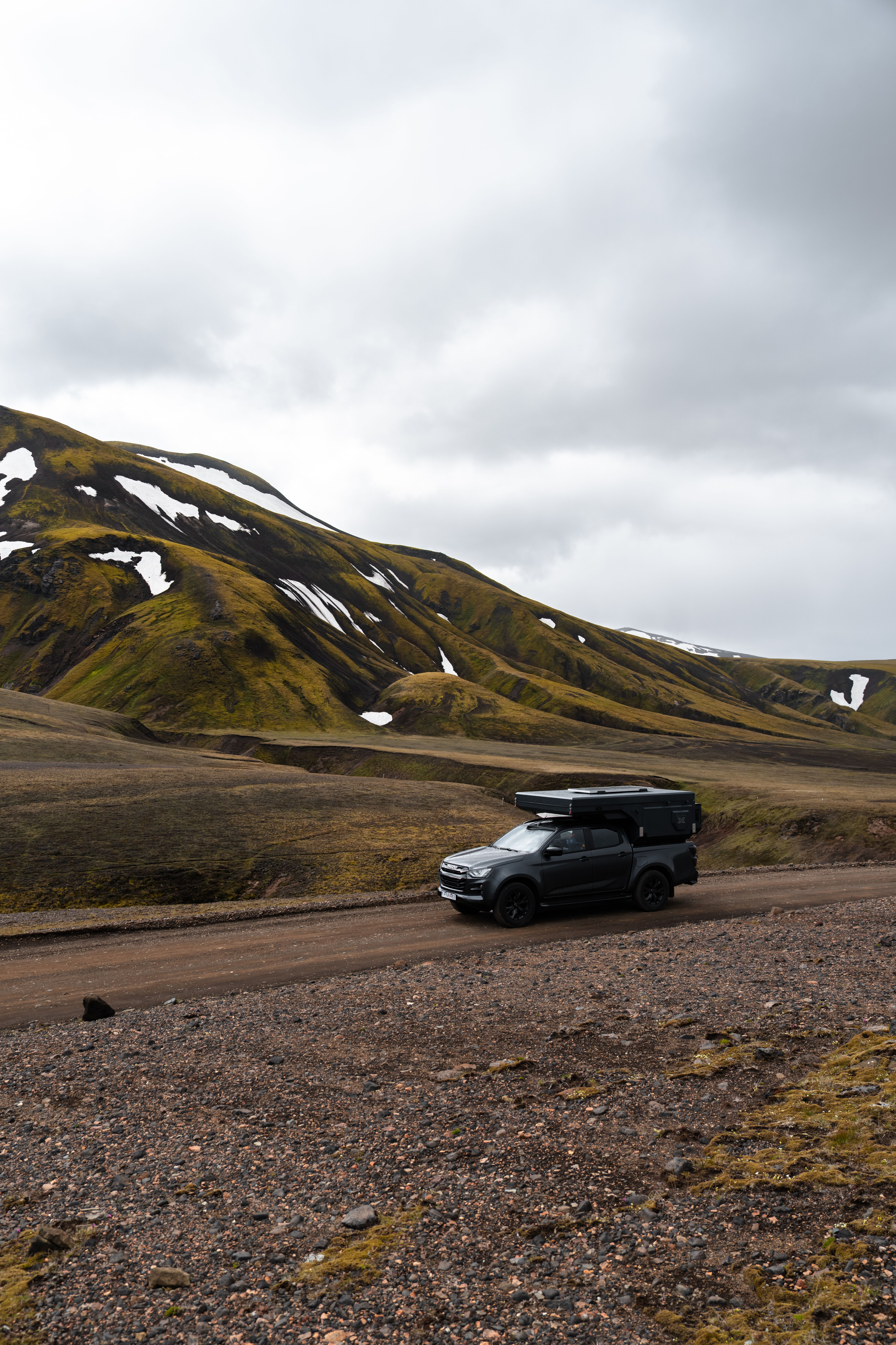 Una autocaravana 4x4 para 2 personas con un módulo trasero rígido en una carretera de grava, alquiler de autocaravanas en Islandia