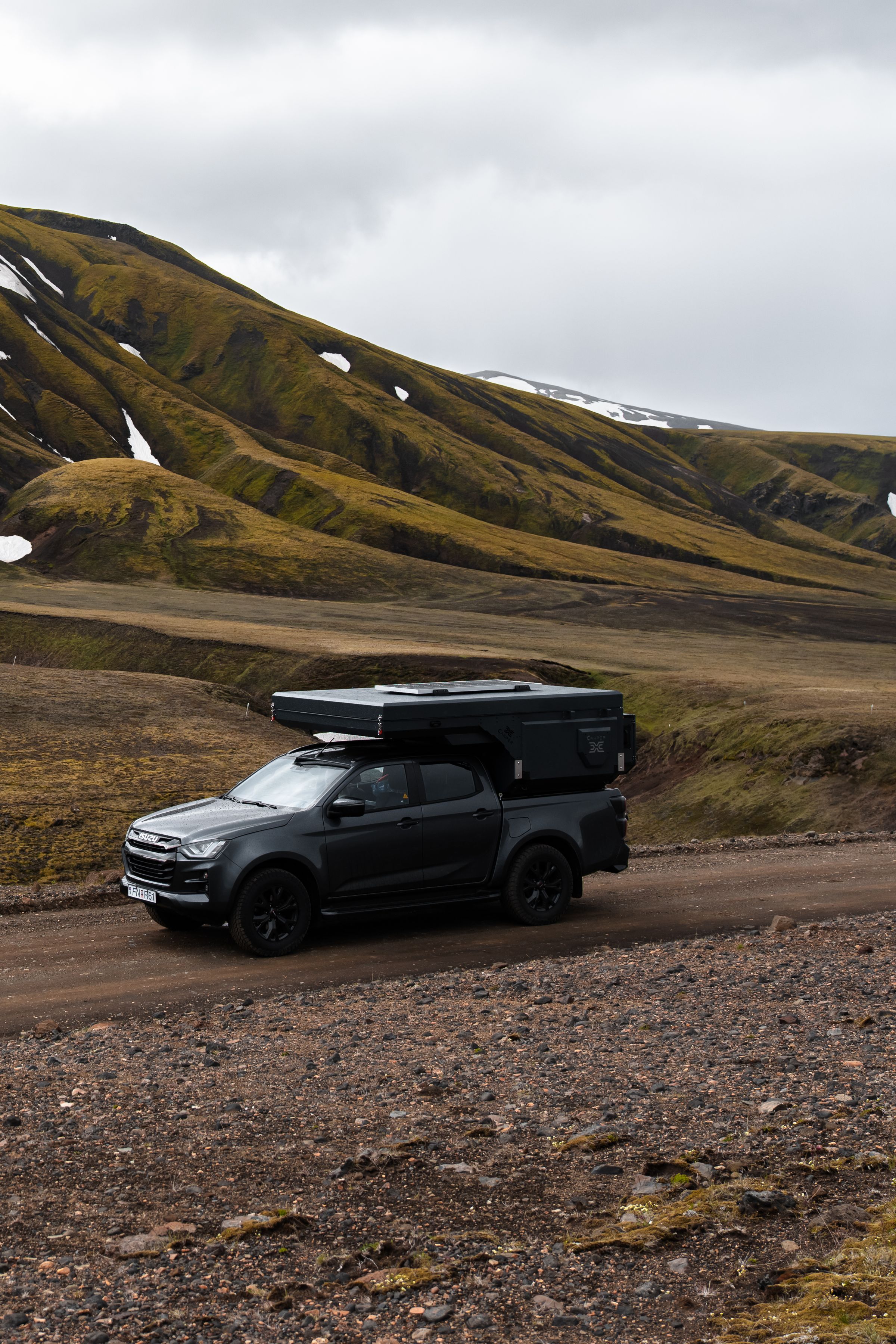 Ruta de grava en camper 4x4 Una autocaravana 4x4 para 2 personas con un módulo trasero rígido en una carretera de grava, alquiler de autocaravanas en Islandia