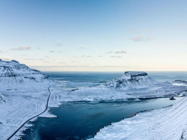 an aerial view of a snowy mountain range with a river running through it .