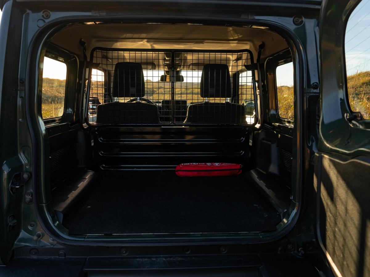 Jimny-Laderaum Suzuki Jimny mit Schaltgetriebe, offenem Laderaum im Heck und Trenngitter hinter den Vordersitzen