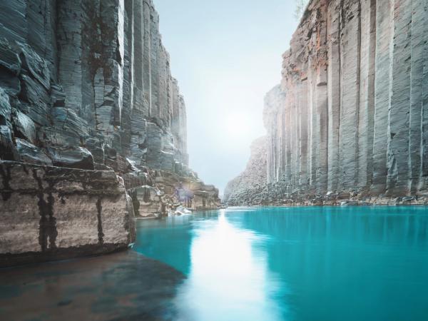 a river runs through a canyon between two rocky cliffs .
