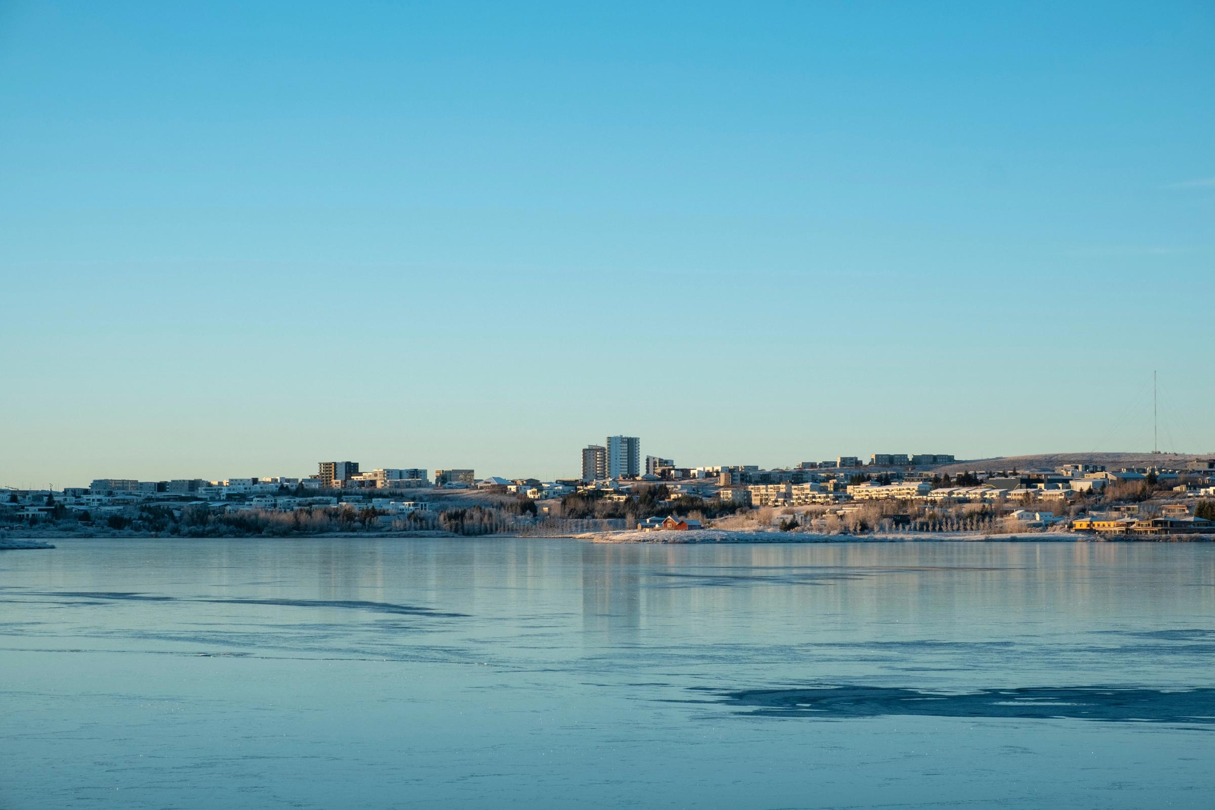 there is a city in the distance and a large body of water in the foreground .