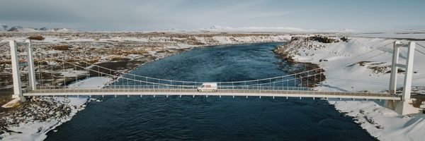 Camper cruzando un puente que pasa por encima de un río