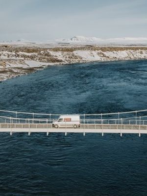 Camper cruzando un puente que pasa por encima de un río