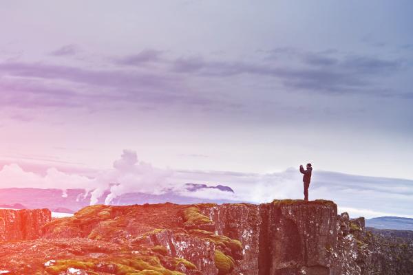 un hombre haciendo una foto con su móvil encima de un acantilado