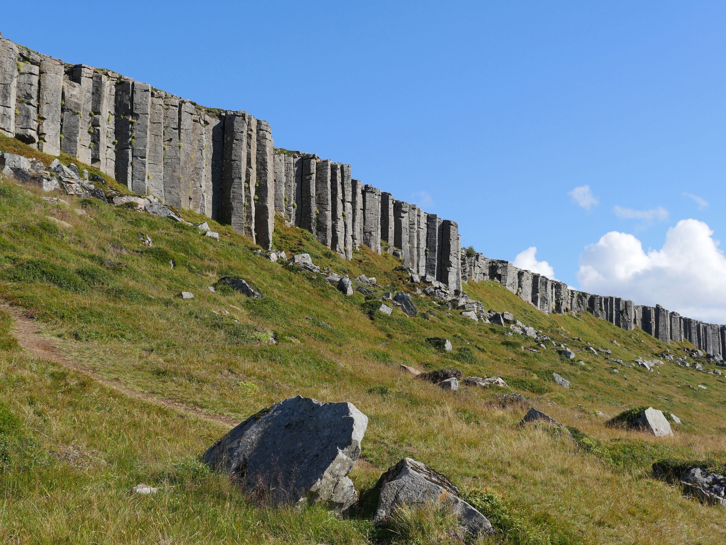 a row of rocks sitting on top of a grassy hill .