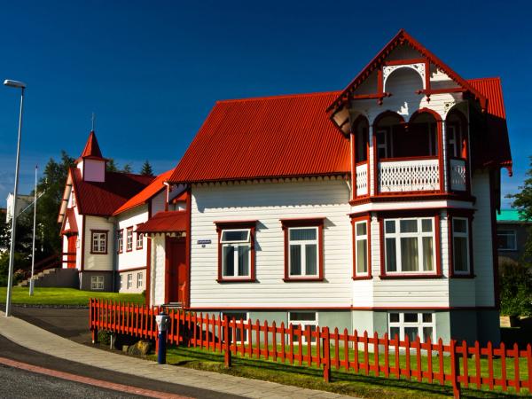 a red and white wood house and church on a sunny day