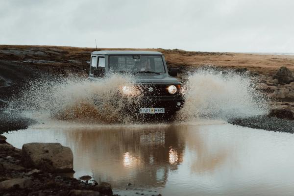 Adventure unleashed: A Suzuki Jimny 4x4 masterfully navigates through an Icelandic river A Suzuki Jimny 4x4 bravely crossing a rushing river in Iceland's rugged terrain