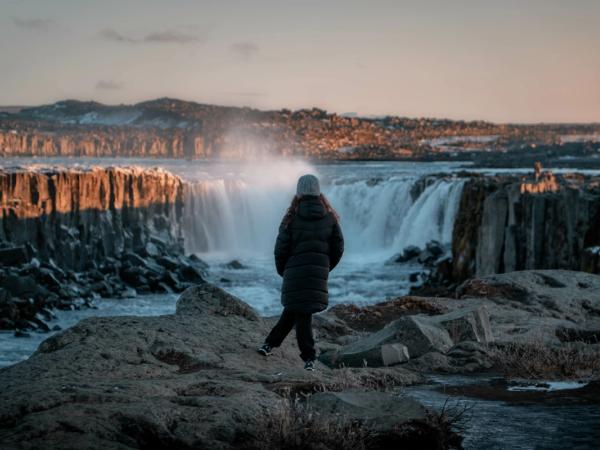 Girl admiring Selfoss waterfall during sunset