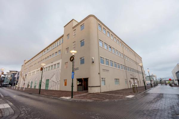 a large building with a lot of windows is on the corner of a street .