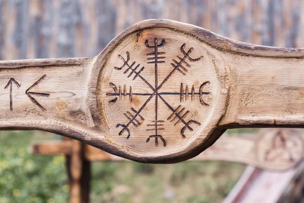 a wooden sign with a symbol carved into it .