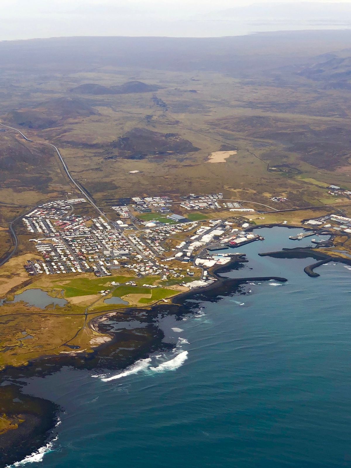 an aerial view of a small town on the shore of a large body of water .