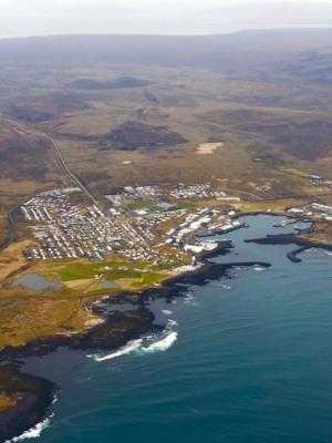 an aerial view of a small town on the shore of a large body of water .