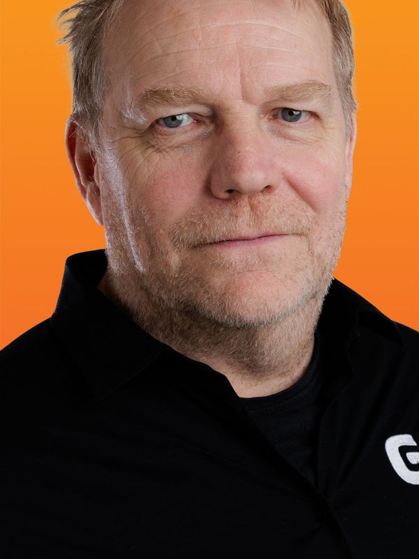 a man wearing a black shirt with the letter g on it
