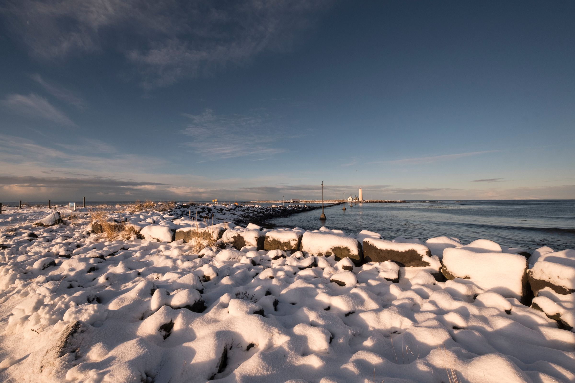 rocas cubiertas de nieve junto al mar