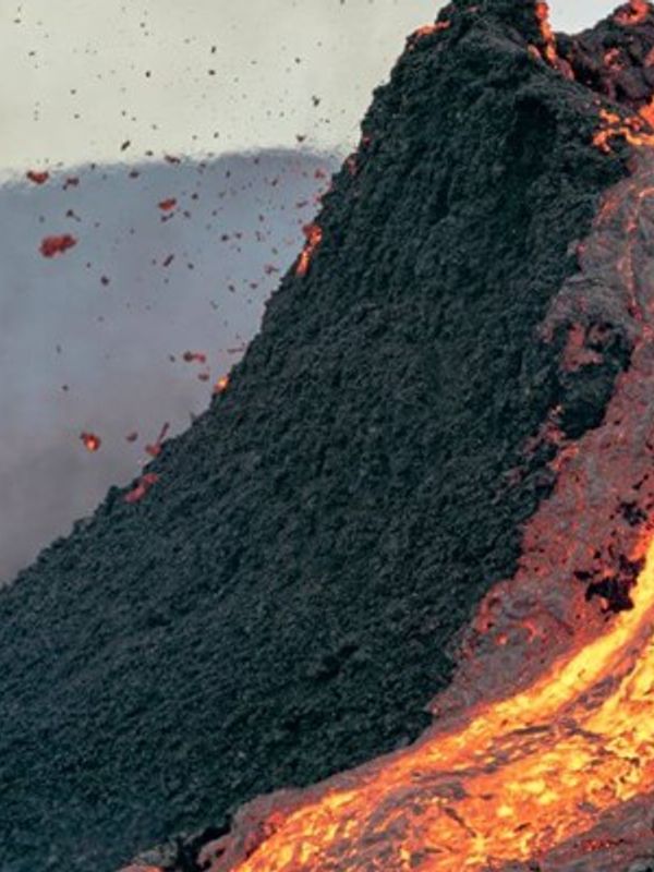 a volcano is erupting and lava is coming out of it .