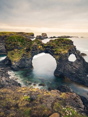 there is a large rock formation in the middle of the ocean .