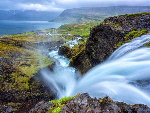 Dynjandi waterfall from above, with a lake in the distance