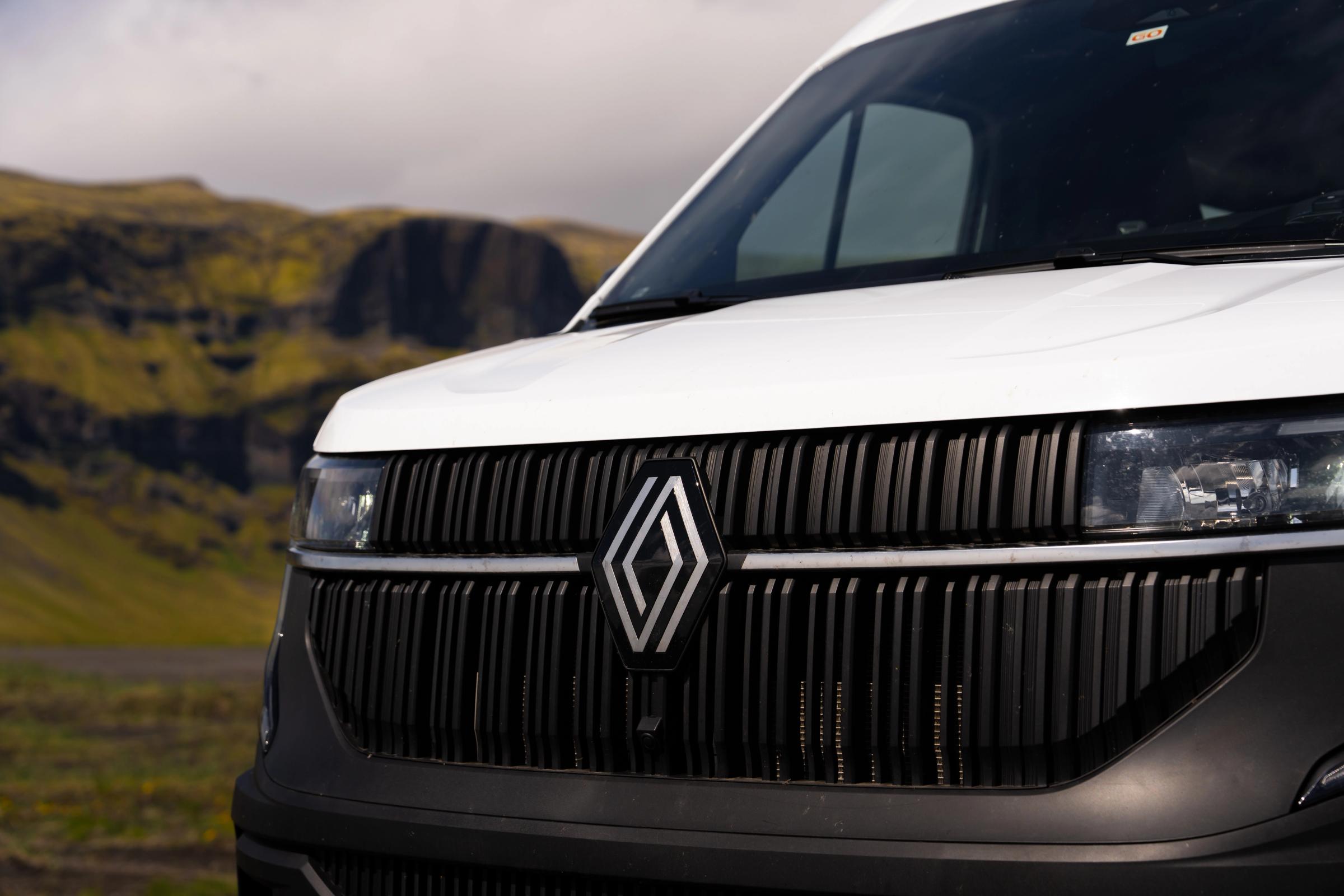 Front grille and headlight close-up with a rocky hillside in the background