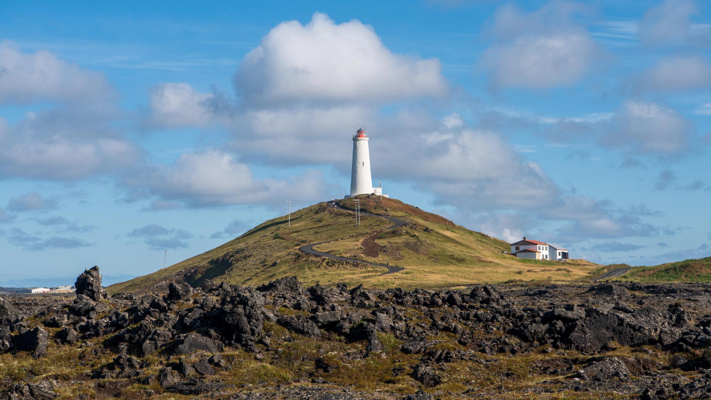 un faro en la cima de una verde colina