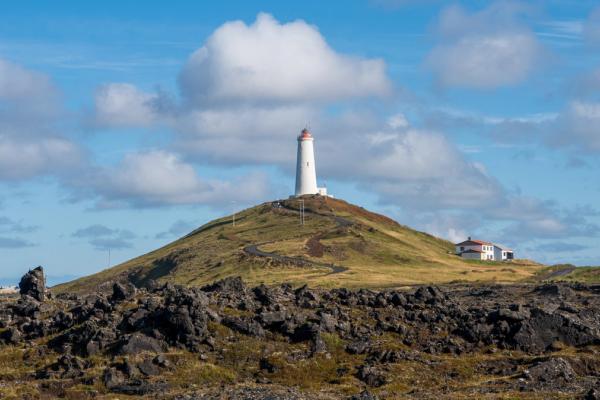 un faro en la cima de una verde colina