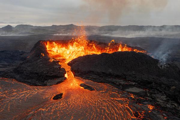 an aerial view of Litli-Hrutur volcano erupting with lava coming out of it .
