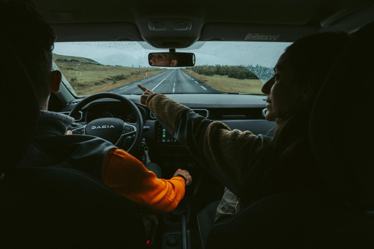 Un homme et une femme conduisant une voiture en Islande.