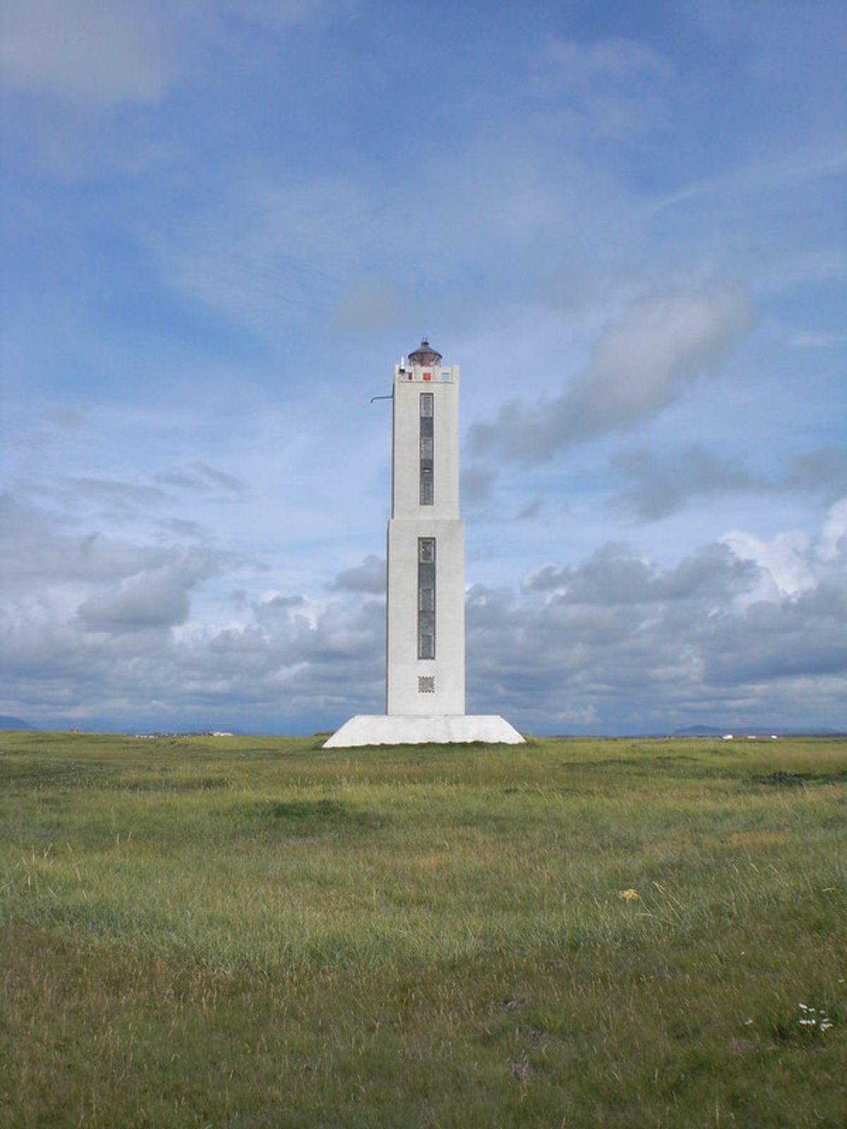 un alto y moderno faro de color claro