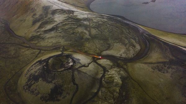 Vista aérea de un coche yendo por una carretera F en las Tierras Altas de Islandia