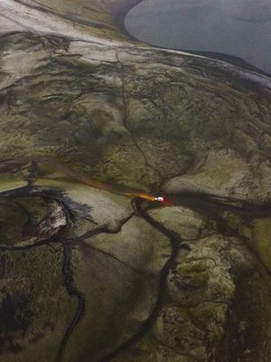 Vista aérea de un coche yendo por una carretera F en las Tierras Altas de Islandia